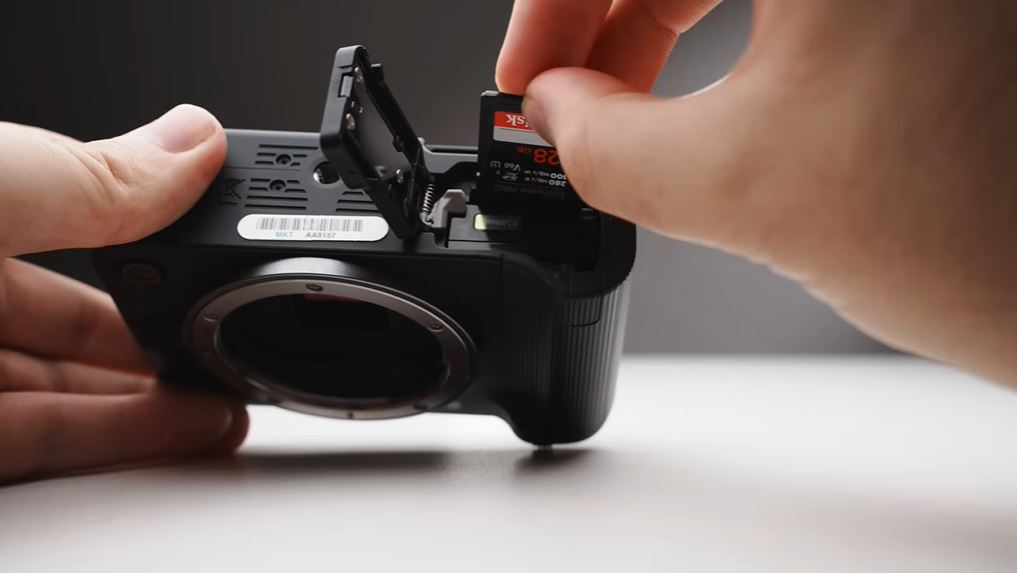 Tháo lắp pin và thẻ nhớ trên Canon EOS R50V khó khăn hơn khi gắn tripod